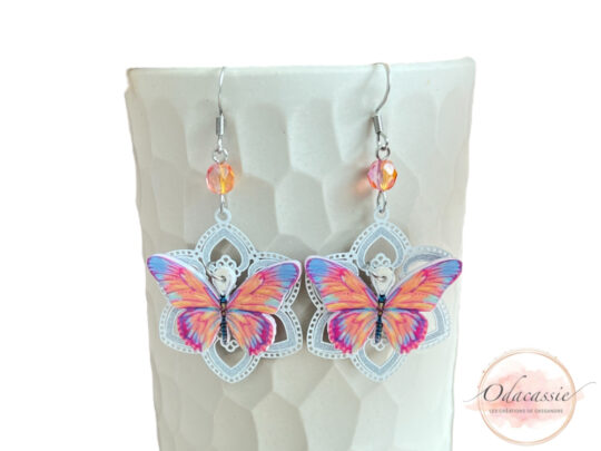 Boucles d'oreilles papillons colorés sur fleurs blanches avec pendentifs résine estampes et perles par Odacassie